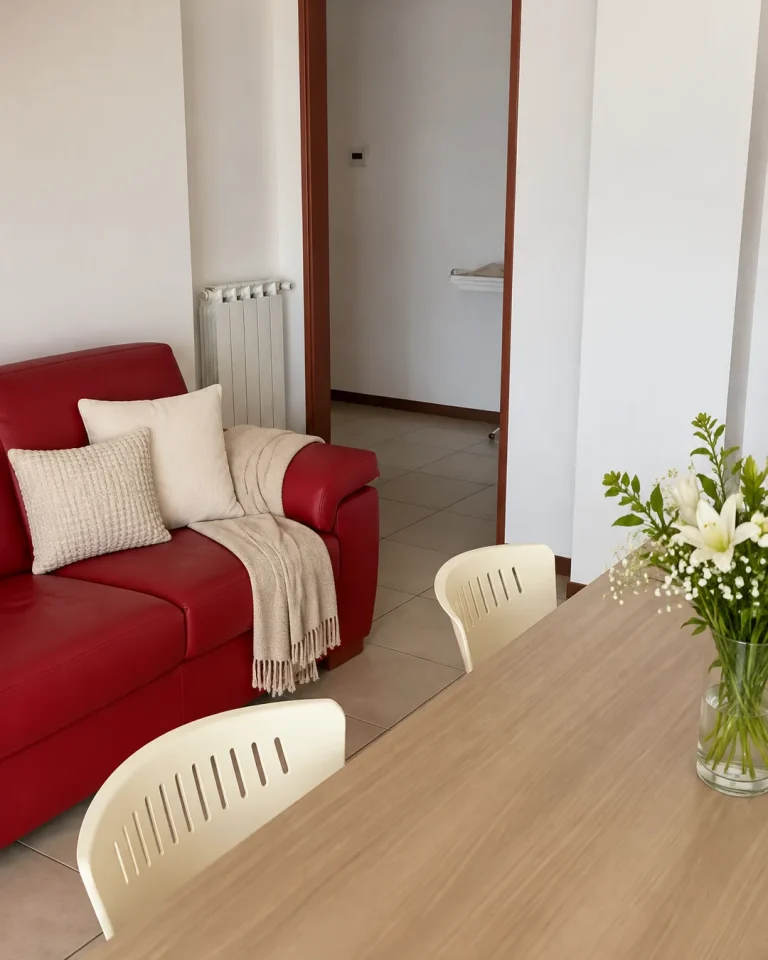 Soggiorno del duplex con divano rosso e tavolo in legno