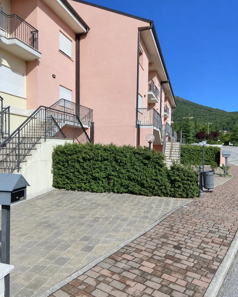 Villini Tipo A visti dal vialetto, con scale esterne e siepe